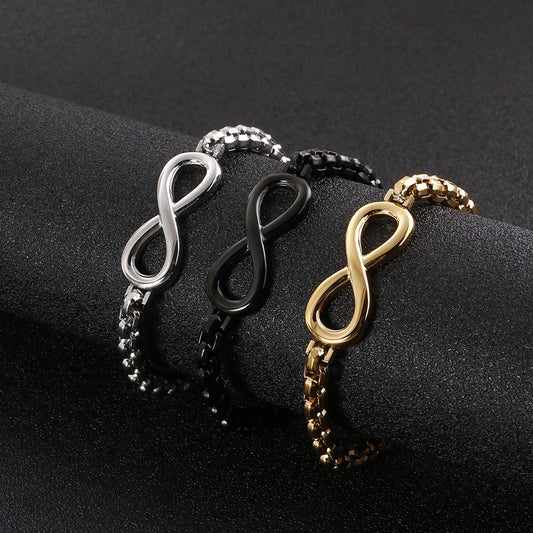 The Infinity bracelet in silver, black, and gold stainless steel, laid flat