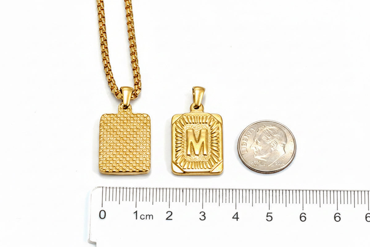 The Initial letter M pendant size comparison next to a dime and ruler